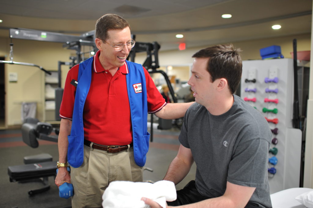 Steve volunteering in the Military Advanced Training Center and working with an amputee.