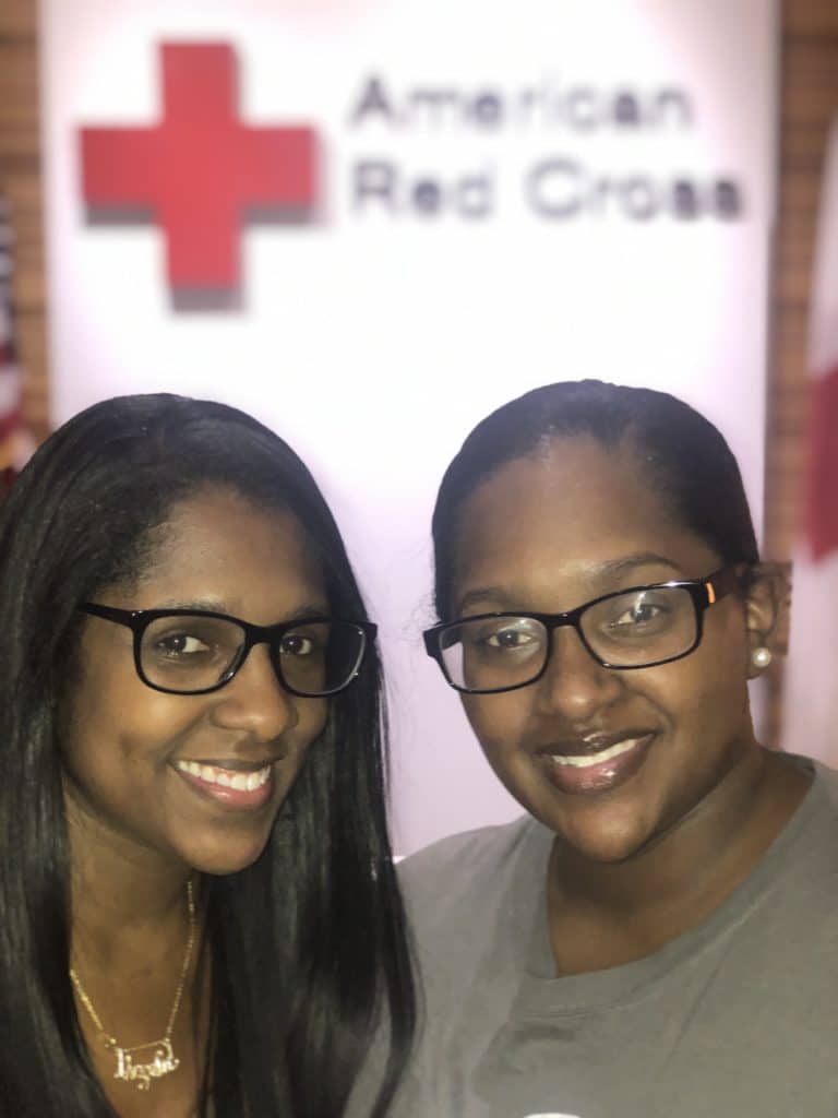 Sisters Danielle Warren (right) and Angela Jackson (left) standing together in their office. 