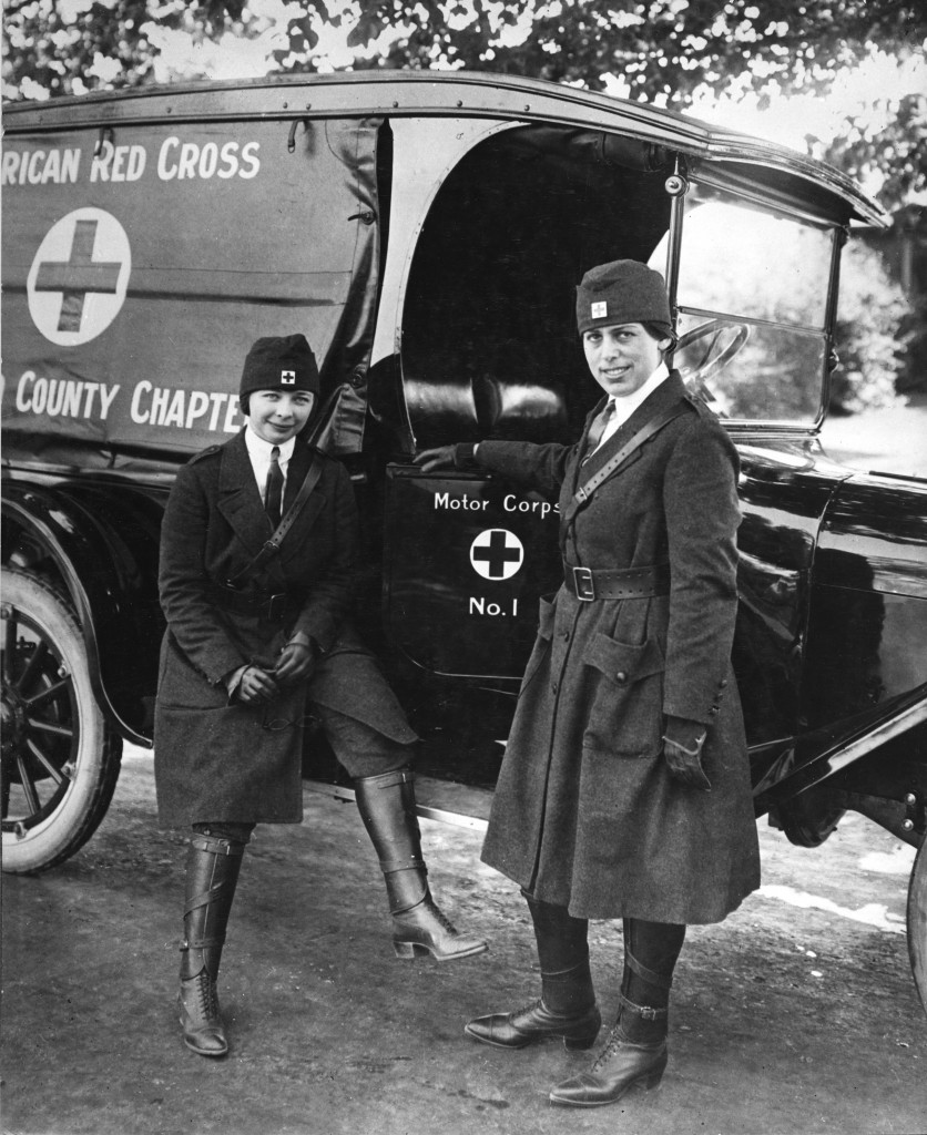 Two members of the San Mateo County Red Cross Chapter proudly display their new uniforms and their shiny motor corps vehicle in a photo taken during WWI. 