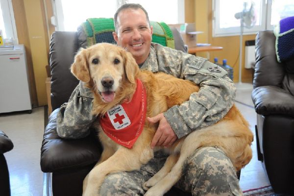 Brian Riddle holds therapy dog Toffee at Landstuhl Regional Medical Center in Germany. 2010.