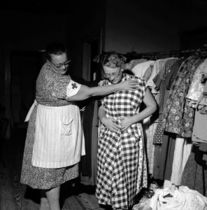 Red Cross volunteer Ada Claessens helps Mildred Ramsey, a fellow victim of Hurricane Carla in 1961, choose a dress from a rack of donated clothing at a shelter in Kemah, Texas.