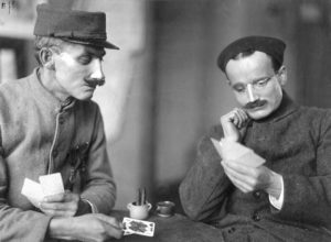 Two soldiers play cards while wearing Ladd’s handiwork.
