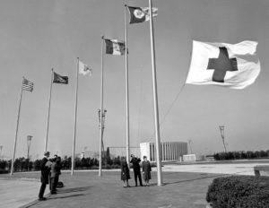 Representatives of the Central Queens Red Cross Chapter help raise the Red Cross flag at Kennedy Airport in March 1967.