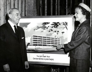 Mrs. Judson B. Shafer, chairman of the Red Cross Benefit Committee, shows Mr. Rodgers a rendering of the new building.