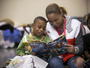 January 3, 2016 -- Garland, Texas -- Red Cross shelter at the Gale Fields Recreation Center. Red Cross volunteer Misty Manglona reads to Jeremiah Moore. Photos by Dennis Drenner for the American Red Cross.
