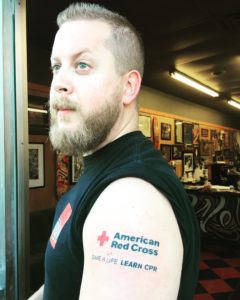 Red Cross tattoo on arm