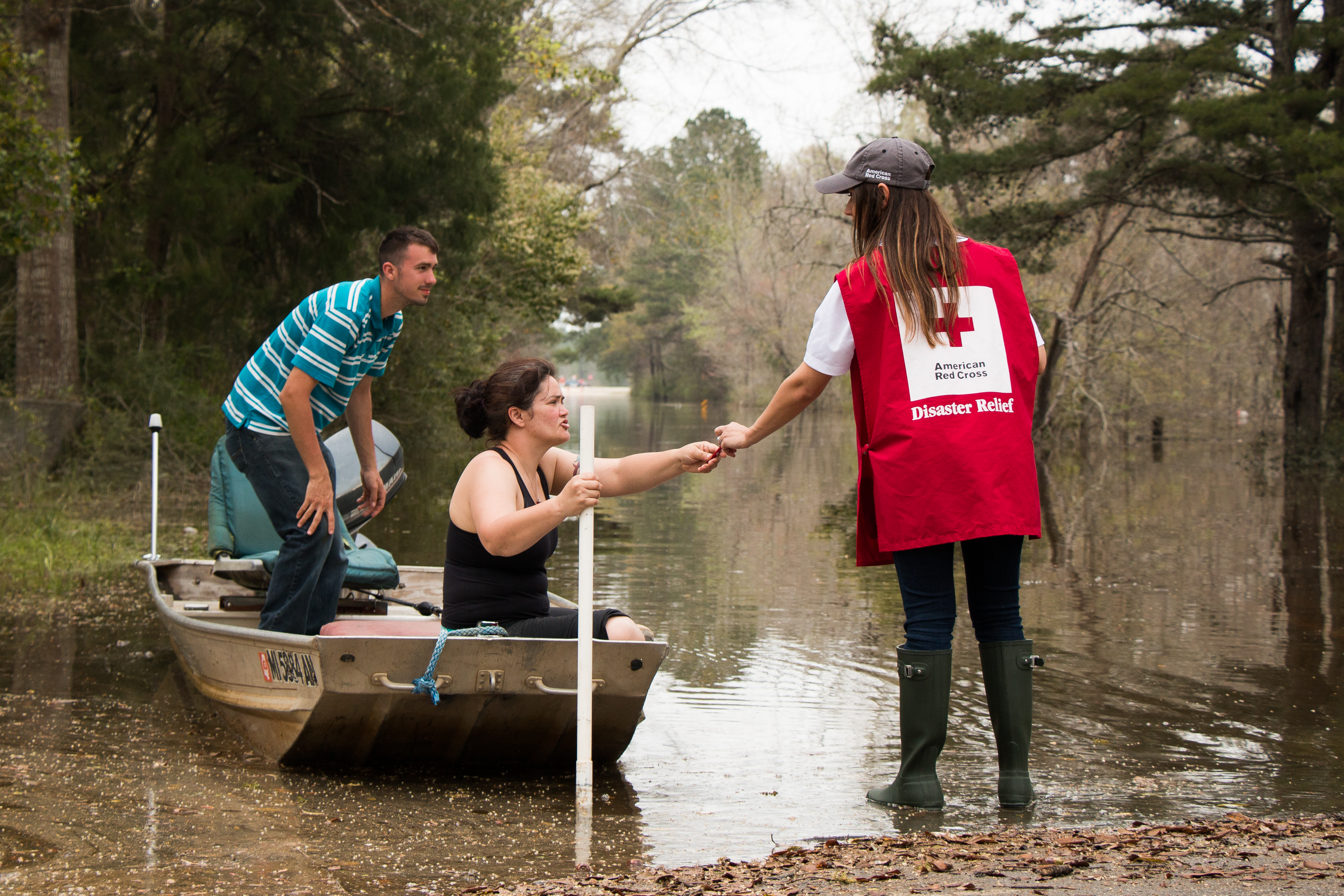 Wednesday March 16, 2016. McClain, Mississippi. Suzy Cooley and Aaron Cooley brave the flood waters on a fishing boat in McClain, MS. Red Cross volunteer, Sarah Basel, notifies them of a nearby Red Cross Point of Contact.