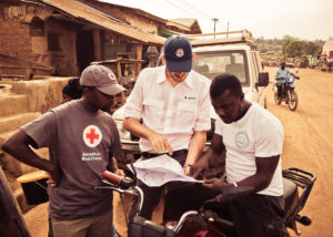 red cross gis lead examines a map in the field international 