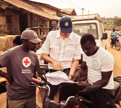 red cross gis lead examines a map in the field international