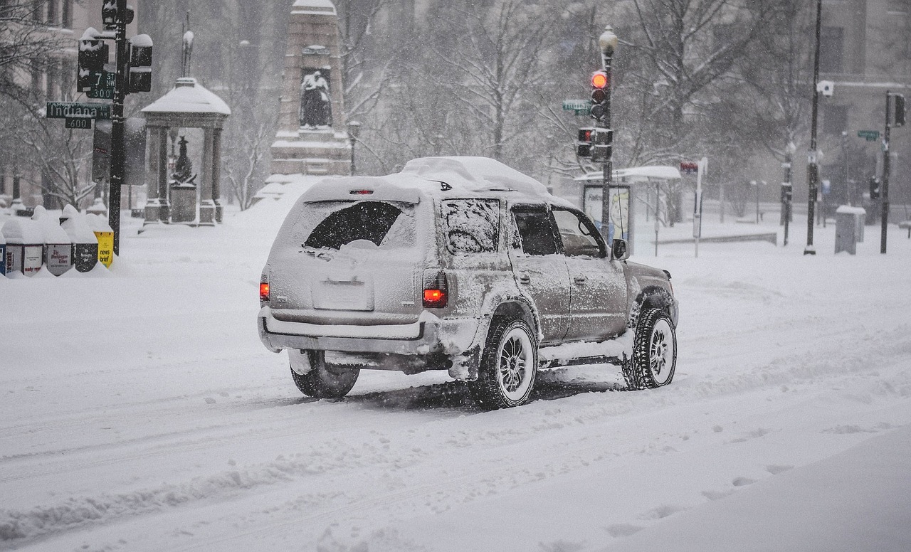 Car driving through snow covered street in snowzilla