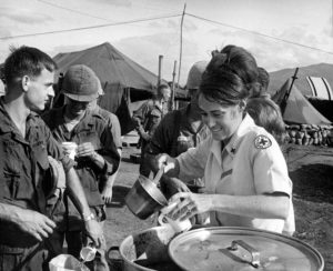 Troops and Donut Dollies: Red Cross recreation worker Glenna Sheeran pitches in on the chow line and visits with servicemen before putting on a program of entertainment for the soldiers.
