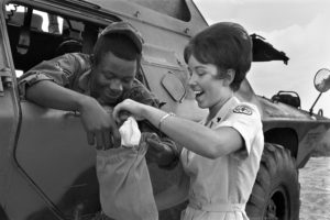 Red Cross Donut Dolly and soldier in Vietnam investigate the contents of his ditty bag. Sgt. Micka was on guard along the Tan Son Nhut air base perimeter in an armored personnel carrier.