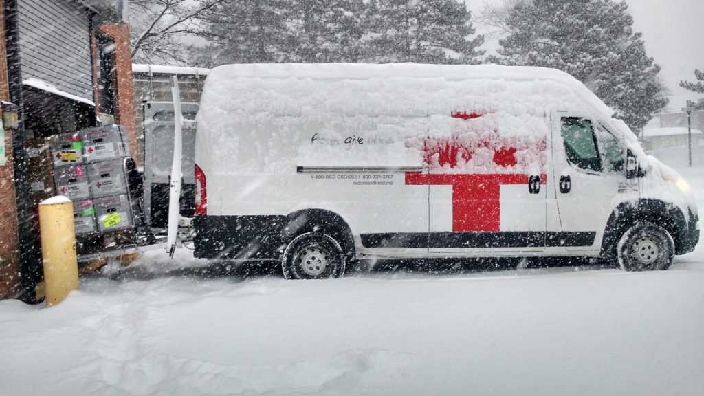 Red cross blood truck covered in snow