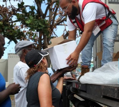Red Cross volunteer hands out relief supplies
