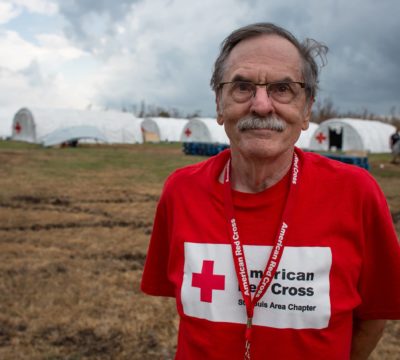 Red Cross disaster relief worker standing in front of Red Cross tent camp for relief workers in Big Pine Key, Florida.