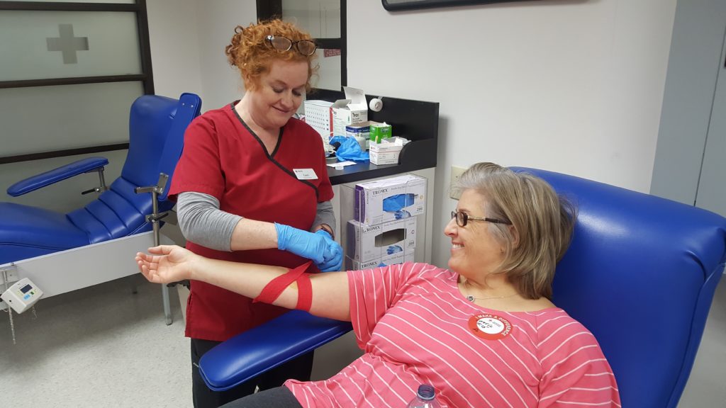 Luci preparing Carries arm for blood donation. 