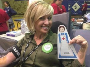 Cutout Clara with Jodi Gerken, while she donates blood at a high school blood drive.