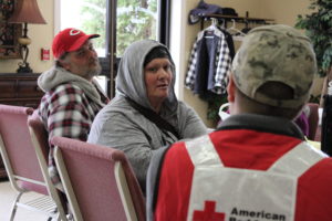 Deborah sitting, talking to a Red Cross volunteer. 