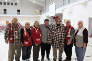 Deborah standing with her husband and five Red Cross volunteers