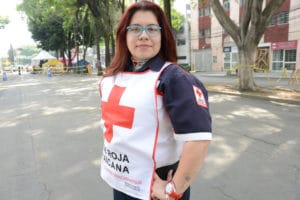 Jazmin standing in the street in her Red Cross gear.