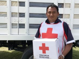 Said holding a box of supplies in his Red Cross gear.