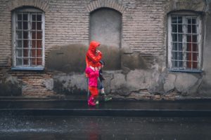 A mother with her two children walking in the rain 