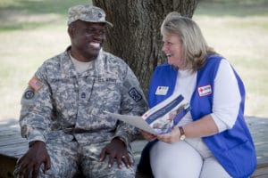 Red Cross volunteer speaking with a member of the military.