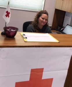 Courtney Penn, a Red Cross nurse, sitting at her desk.
