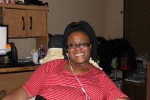 Volunteer, Ebony Deloach, in her wheelchair smiling.
