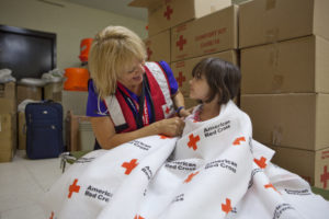 Volunteer Melody Belloff, a nurse, wraps up Kairi to keep her warm at a Red Cross shelter in Wickenburg, Arizona,