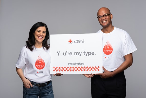 A man and a woman wearing Missing Types blood donation t-shirts. 
