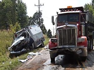 A picture of the wrecked ambulance and dump truck on the side of the road.