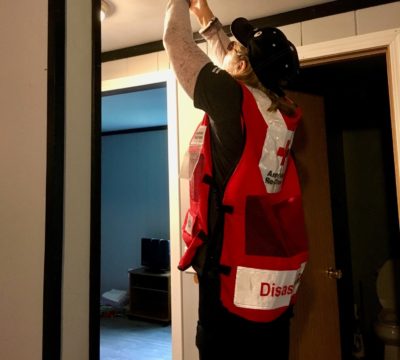 A Red Cross volunteer installking a smoke alarm in Stony River.