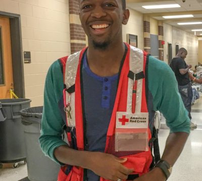 Tramone Hester smiling and standing in his Red Cross vest.