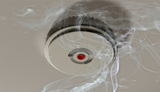 A picture of a smoking smoke alarm. 