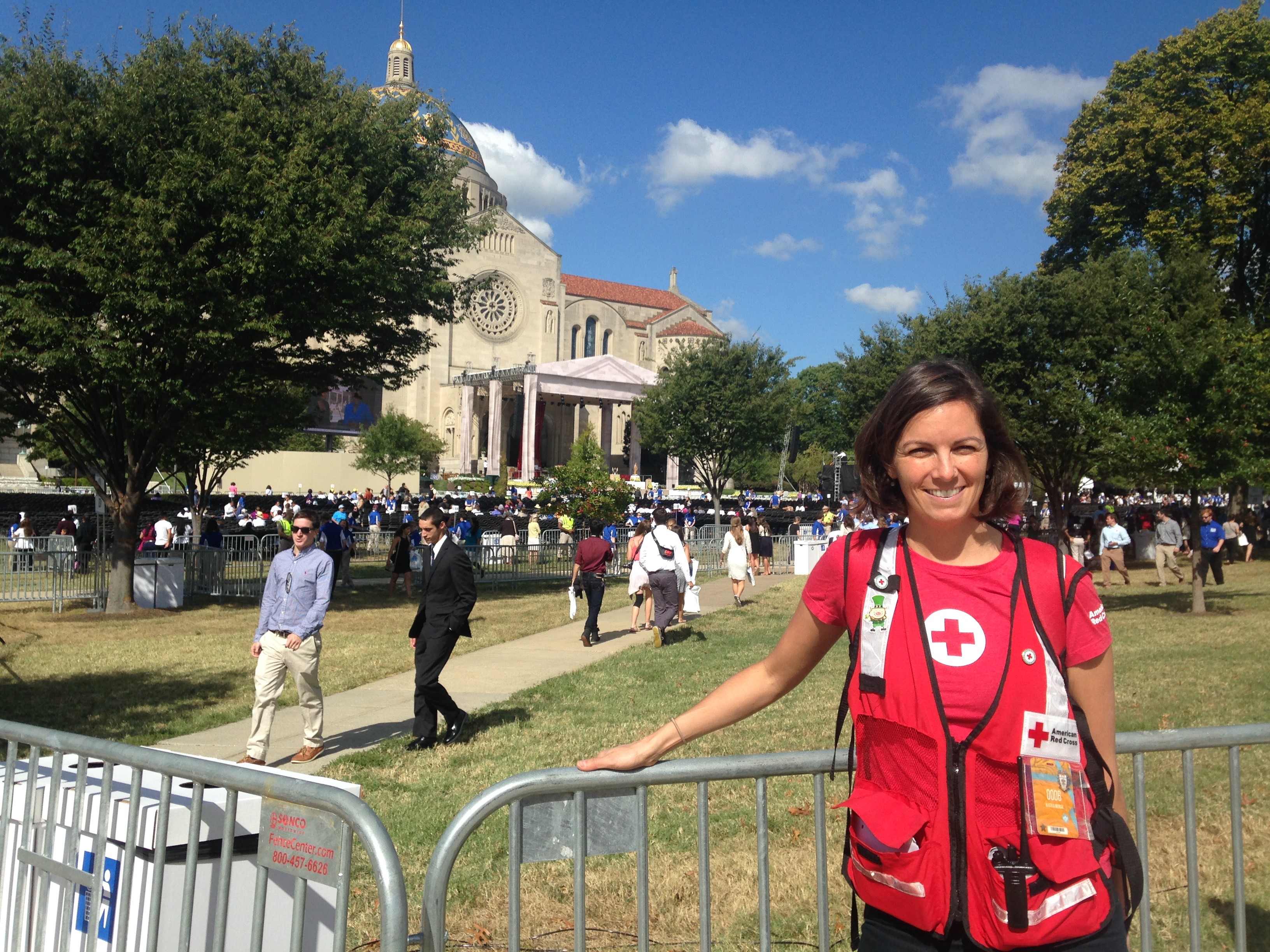Christie standing in front of a gate in her Red Cross vest. 