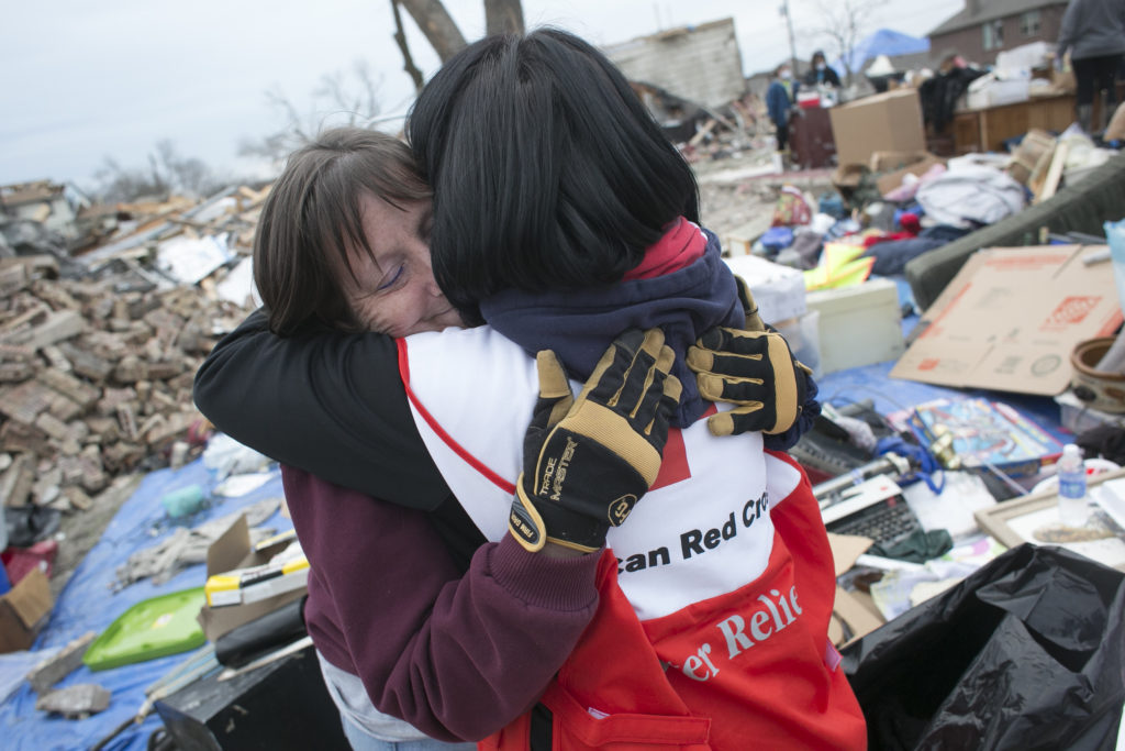  A Red Cross volunteer hugging a disaster victim. 