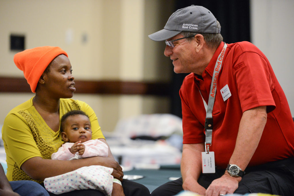 Nyasa and her 3-month old daughter talking to a Red Cross volunteer in a shelter. 