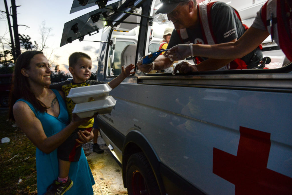 Jenna and her son Leo receive a hot meal from a Red Cross emergency response vehicle. 