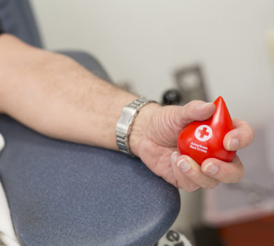 A picture of a blood donor holding a blood donation stress ball.
