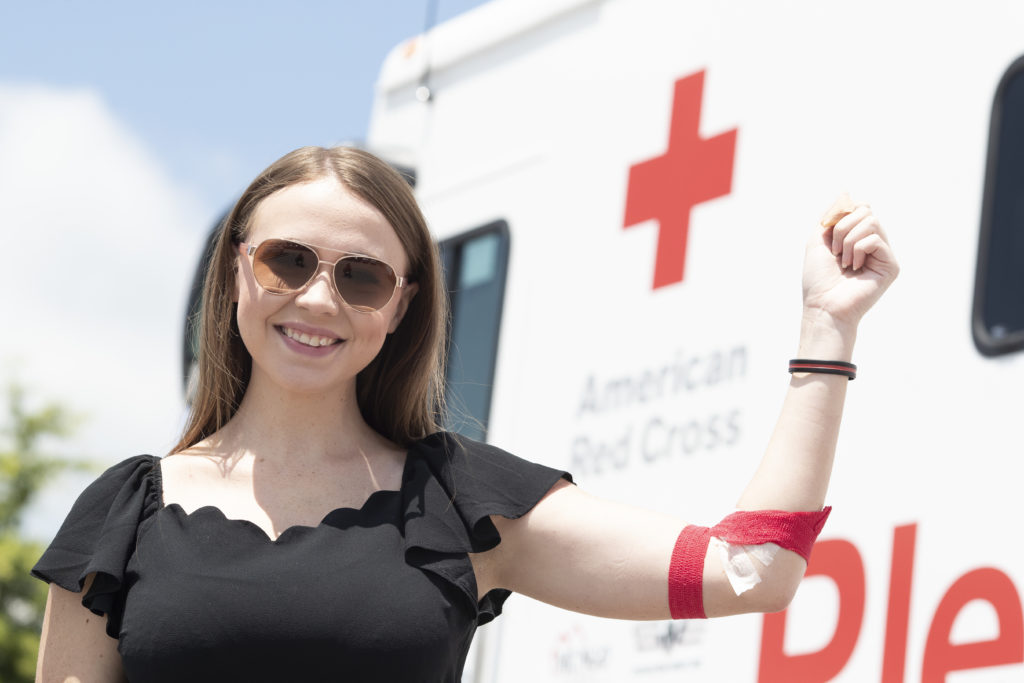 A blood donor holding up her arm after she donated blood. 