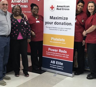 Kirk Davis standing with phlebotomists at a blood center in North Carolina.