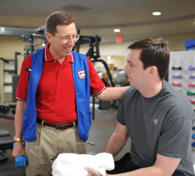 Steve volunteering in the Military Advanced Training Center and working with an amputee.