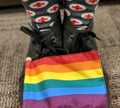 A closeup of Leah's shoes and Red Cross social with a Pride flag.