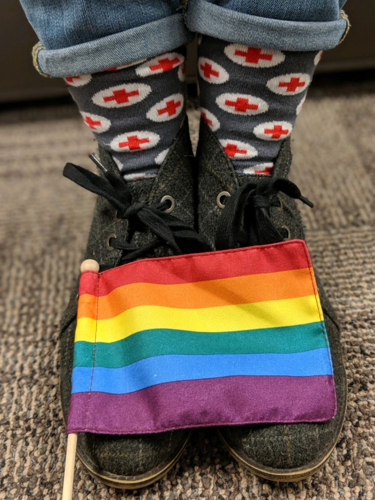 A closeup of Leah's shoes and Red Cross social with a Pride flag.