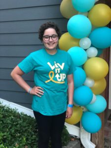 Olivia Stoy smiling next to balloons.