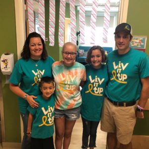 Olivia standing with her family at the hospital.