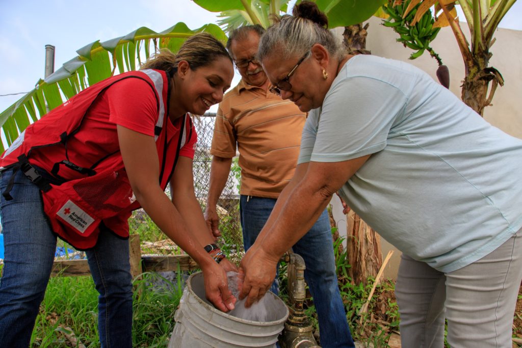 Rosemarie washing her hands with a family during Hurricane Maria.
