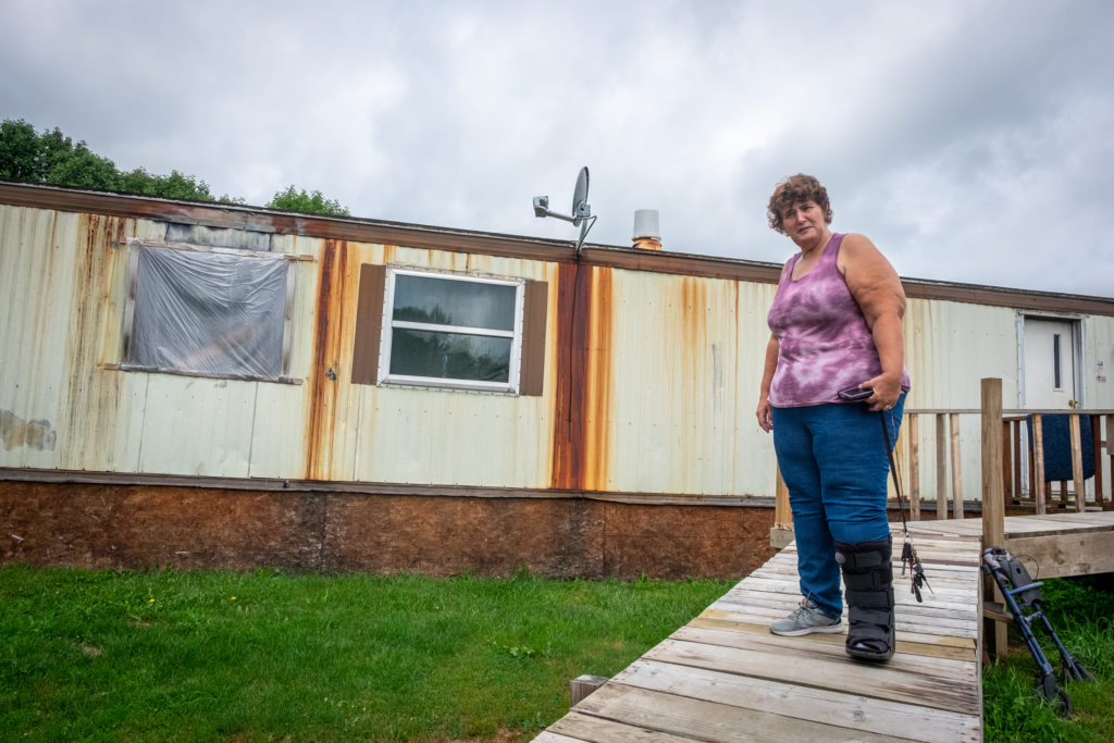 Margaret Phillips standing outside of her damaged home. 