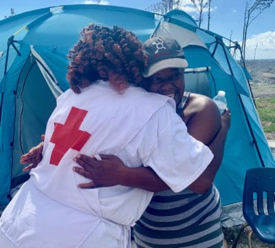 A Bahamas resident hugging an emotional support volunteer.